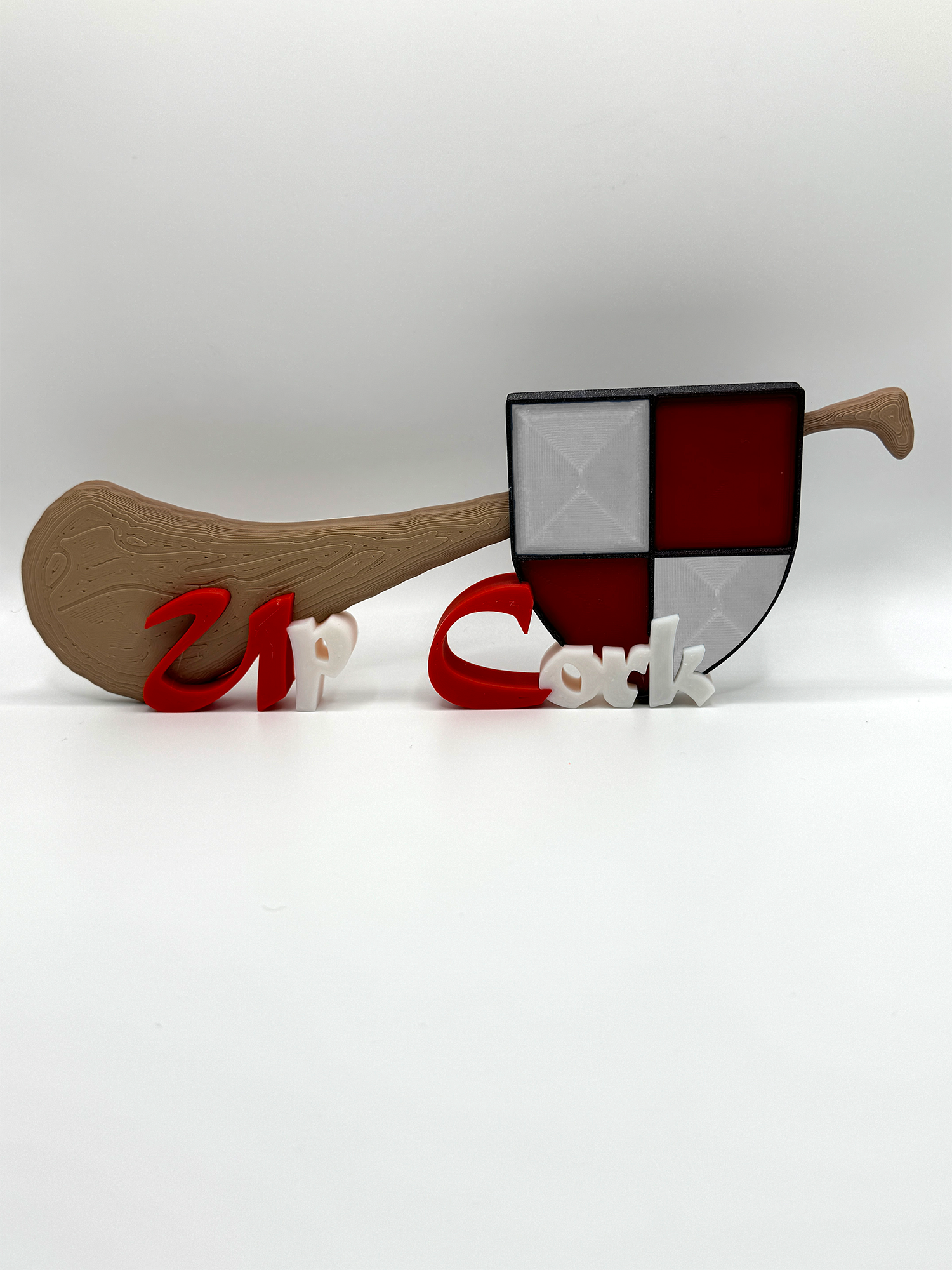 Custom hurley name plaque with 'Up Cork' text, featuring a wood-textured handle and patchwork blade in red, blue, and grey. Perfect for Cork hurling fans.